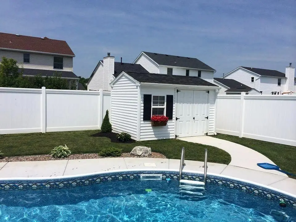 A pool with a house in the background