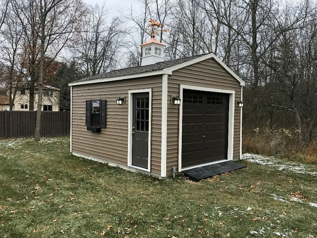 A brown and white shed with a window.