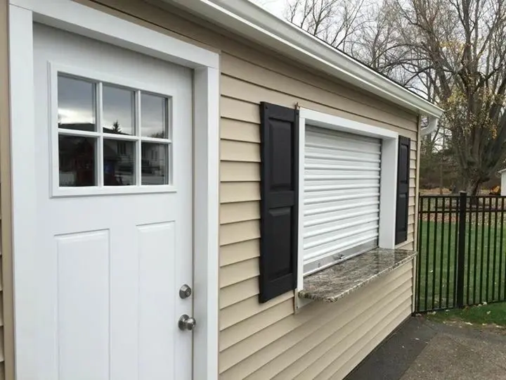 A garage with shutters and a window.