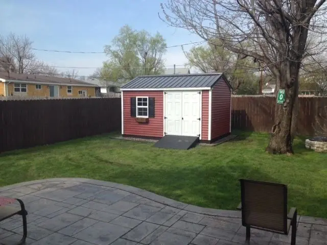 a red shed next to tree without leaves