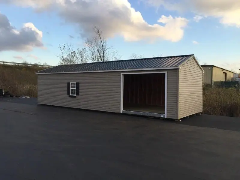 A shed with a door open in the middle of a lot.