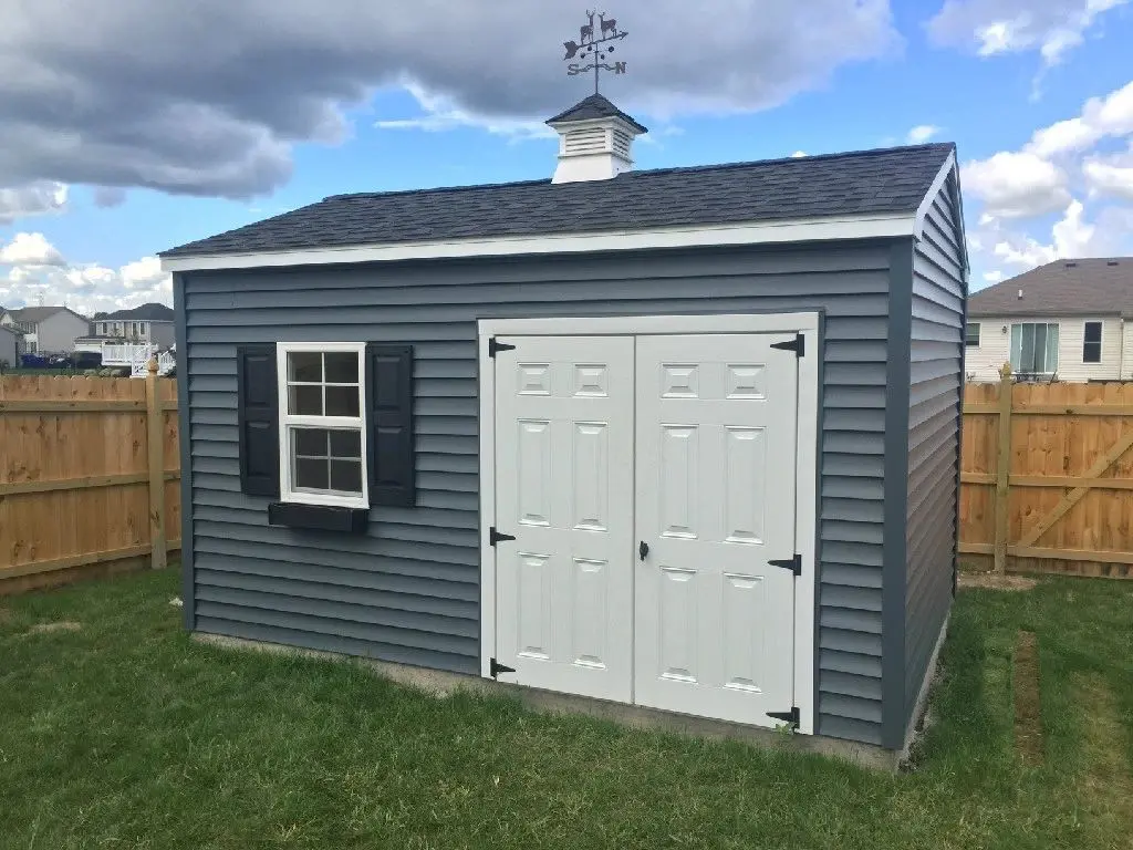a blue shed with a cupola and double doors