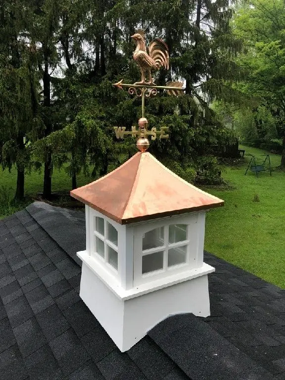 A white and copper cupola sitting on top of the roof.