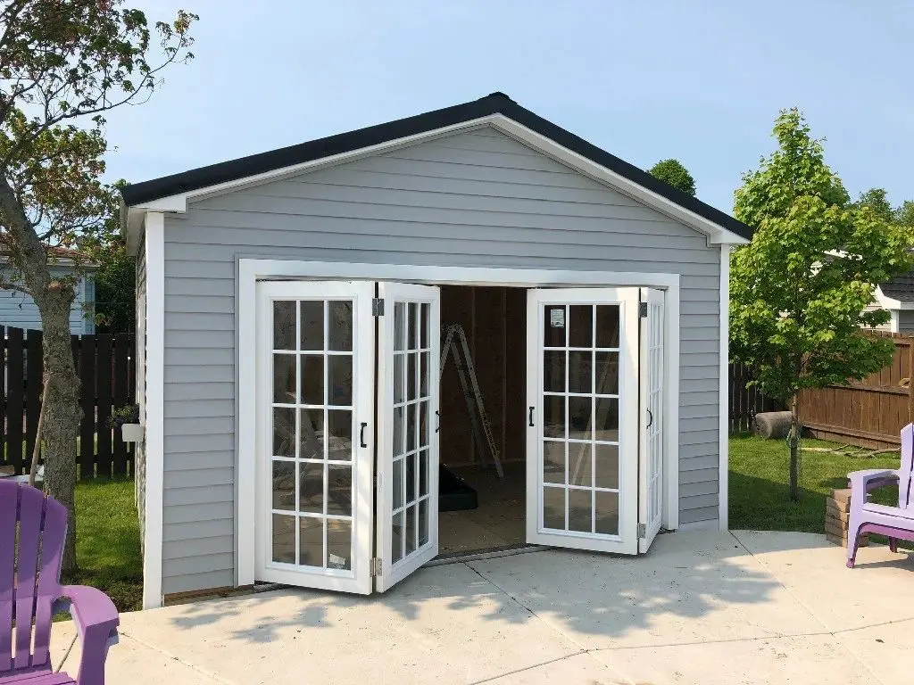 A gray shed with two french doors open.