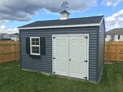 A blue shed with two white doors and a black roof.