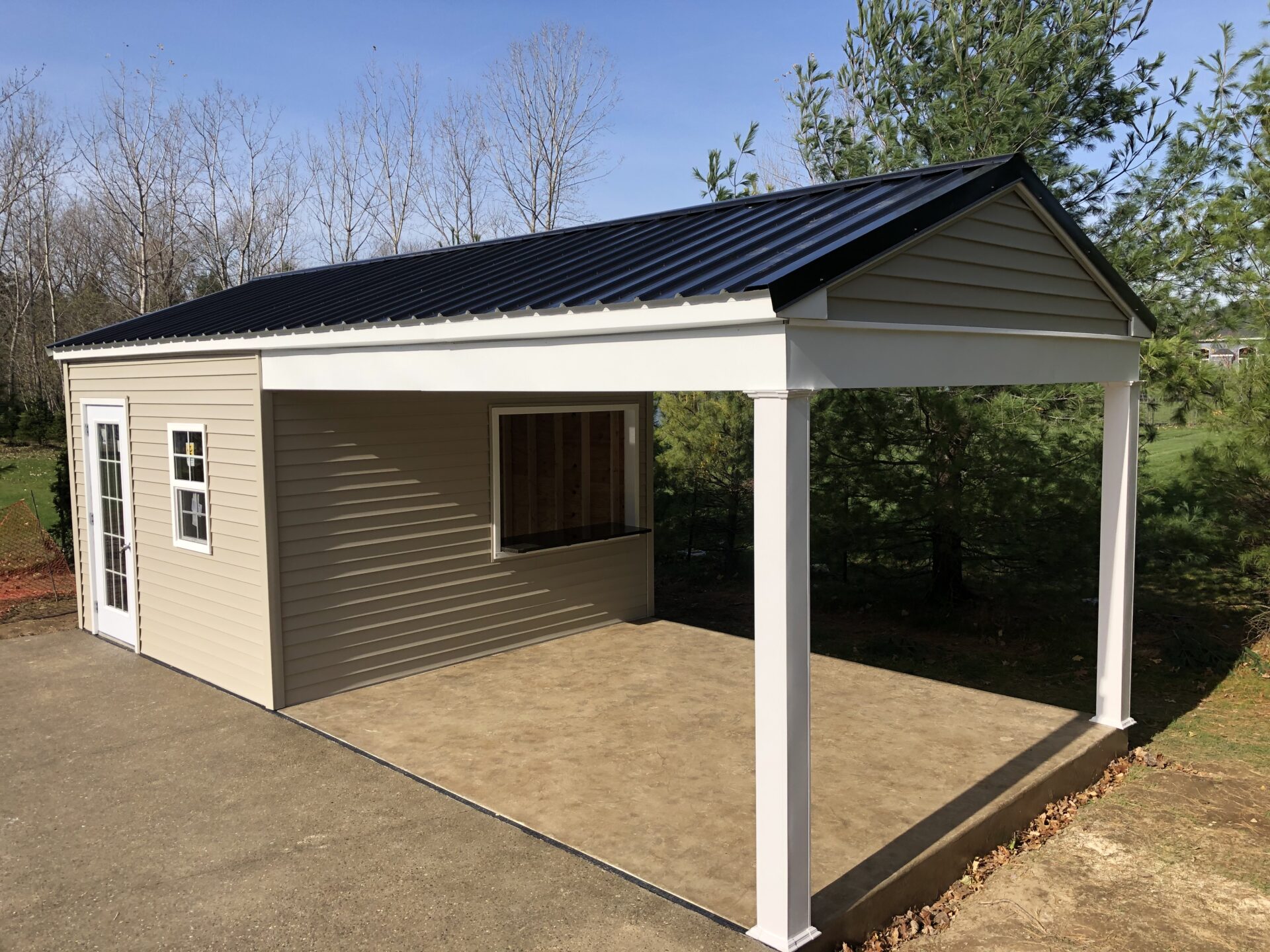 A carport with a black roof and white walls.