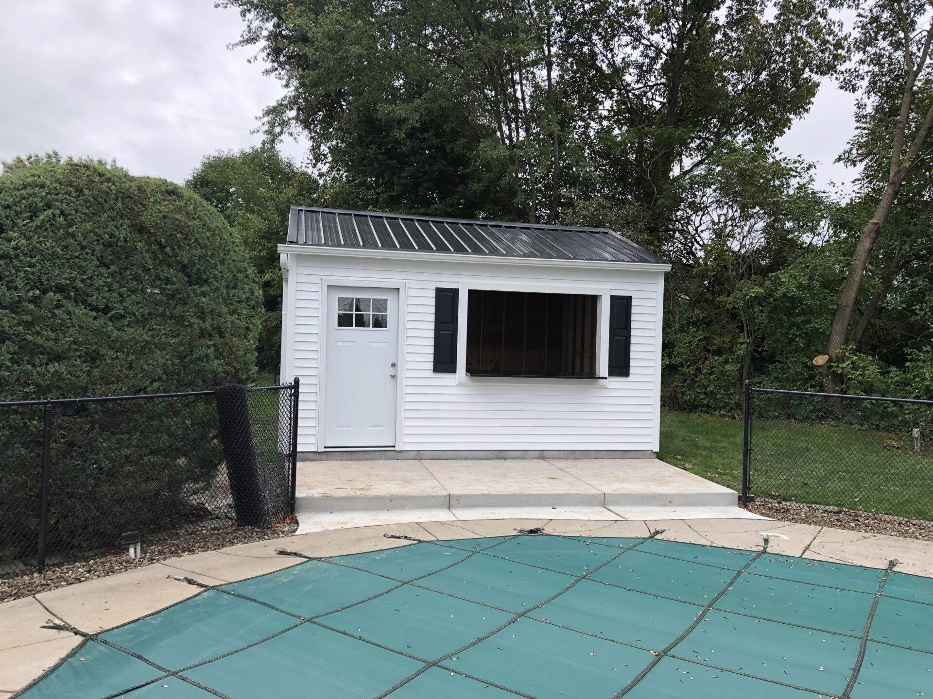 A white shed sitting next to a pool.