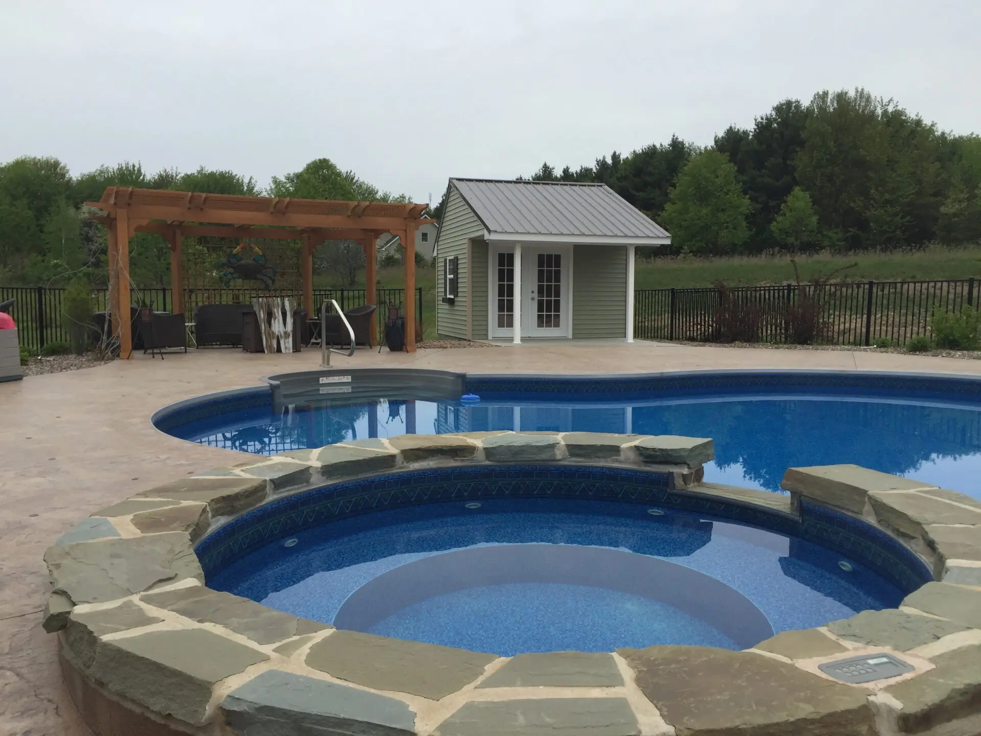 A pool with a hot tub in the middle of it