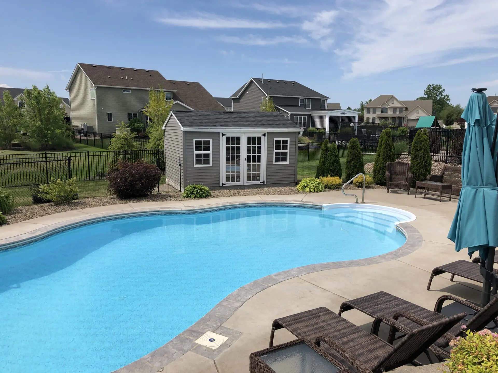 A pool with a house in the background