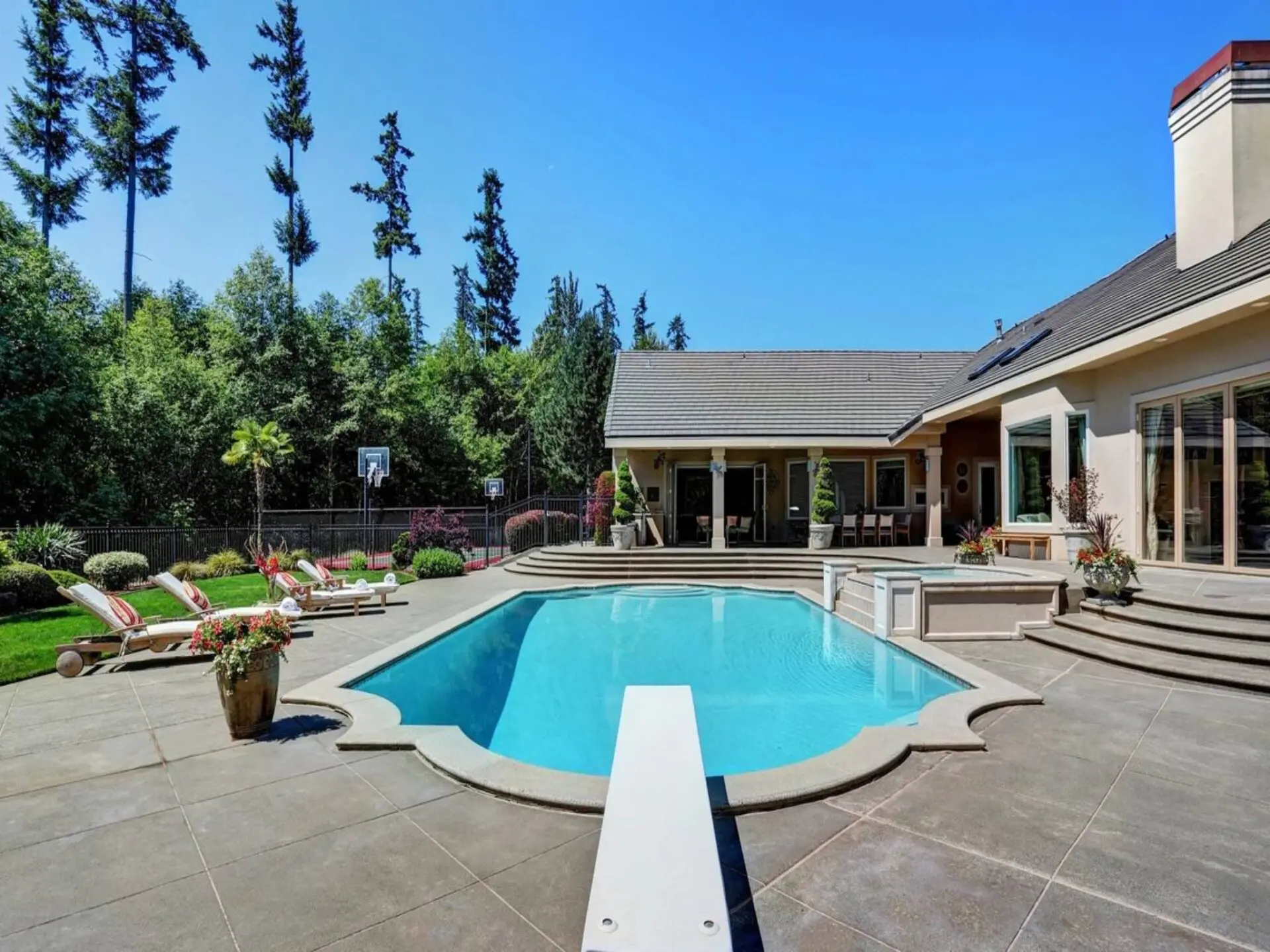 A pool with an open roof and a large deck.