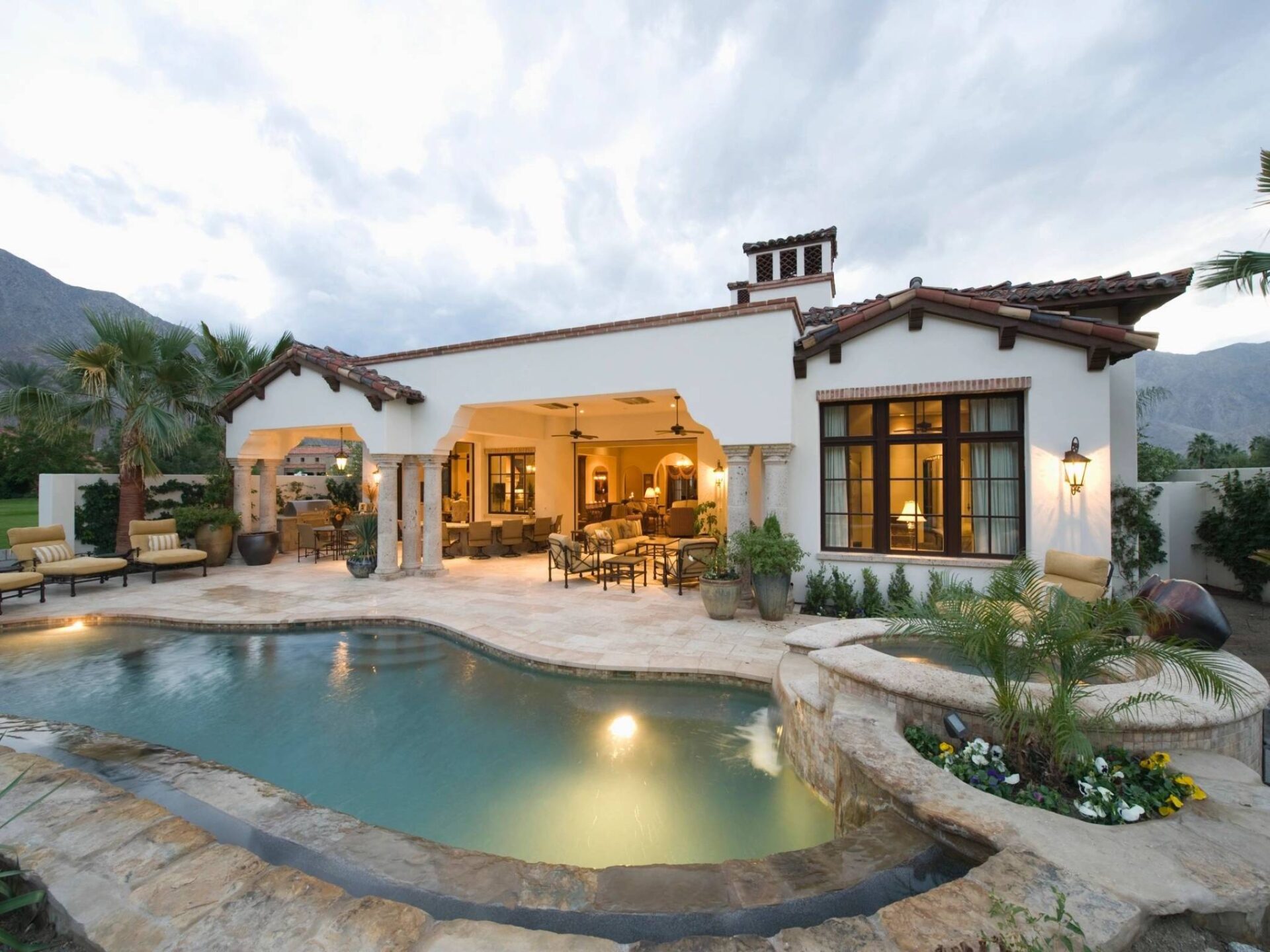 A pool with a patio and outdoor furniture.