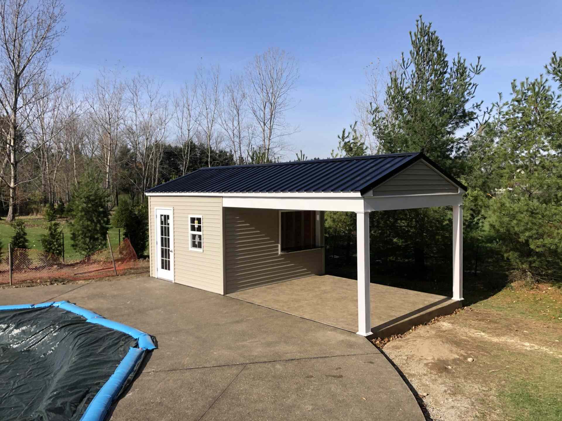 A pool house with a metal roof and a concrete floor.