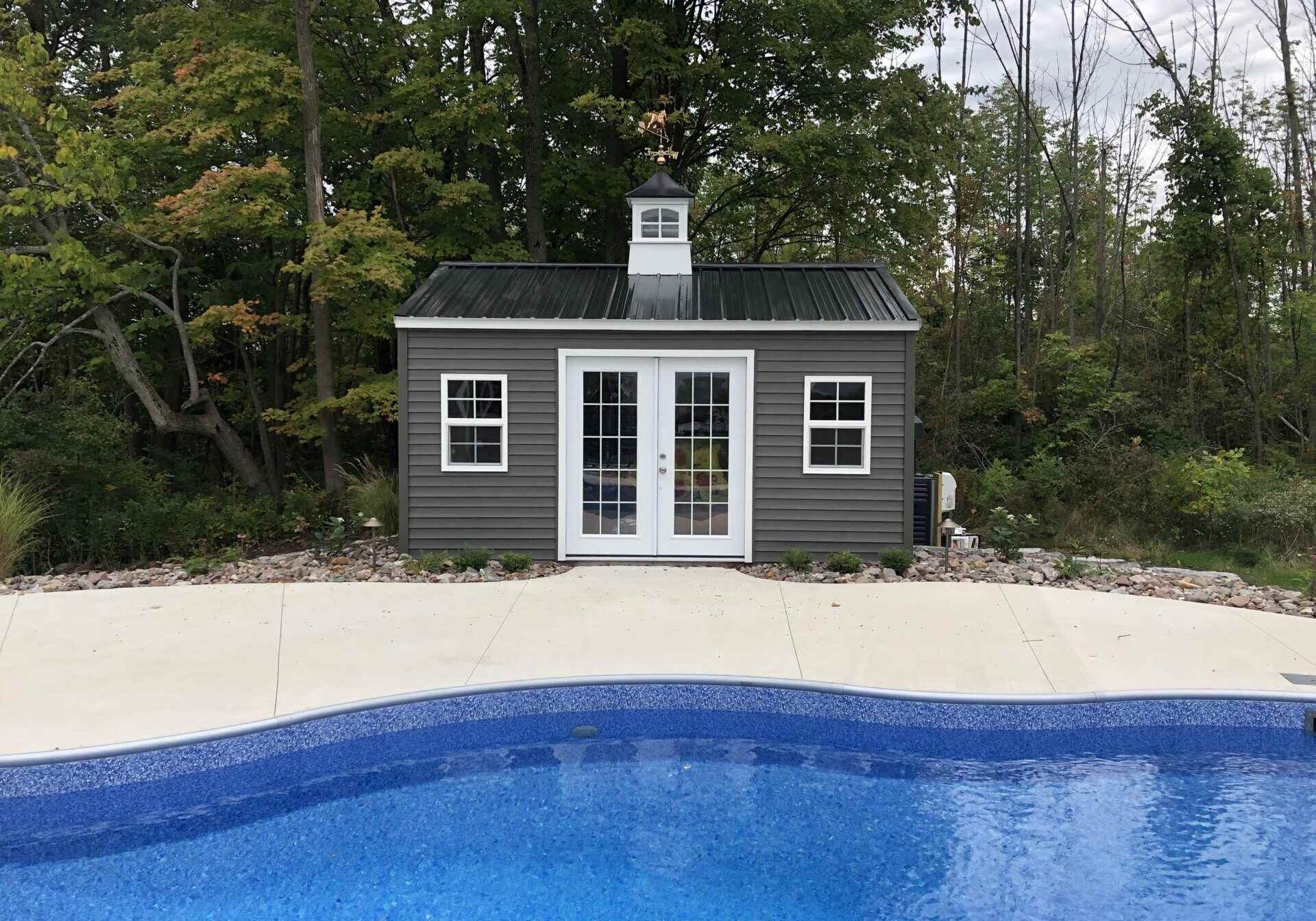 A pool house with a door open and a window.