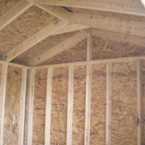 A wooden shed with some wood in it