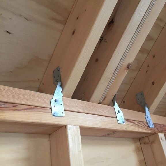 A close up of some wooden beams with metal brackets