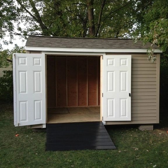 A shed with two doors and a ramp in the front.