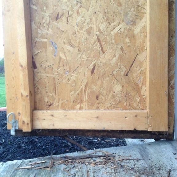 A wooden door that is being boarded up.