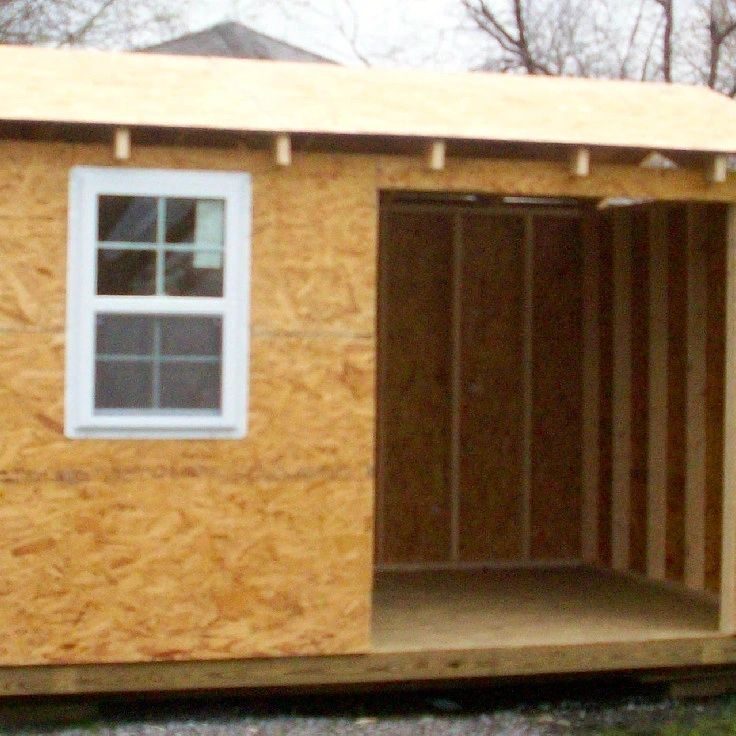 A shed with windows and doors in the middle of it.