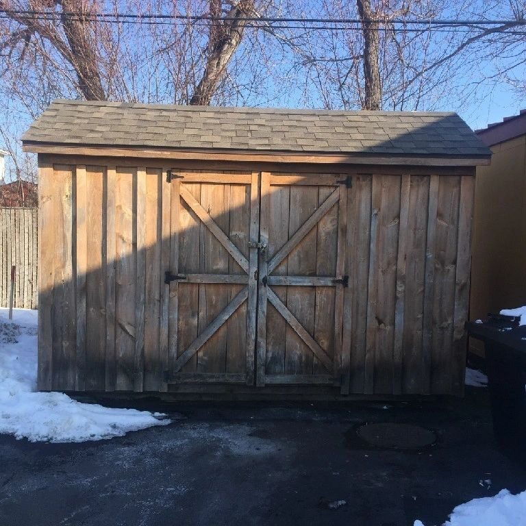 A wooden shed with a large door and a big barn style door.