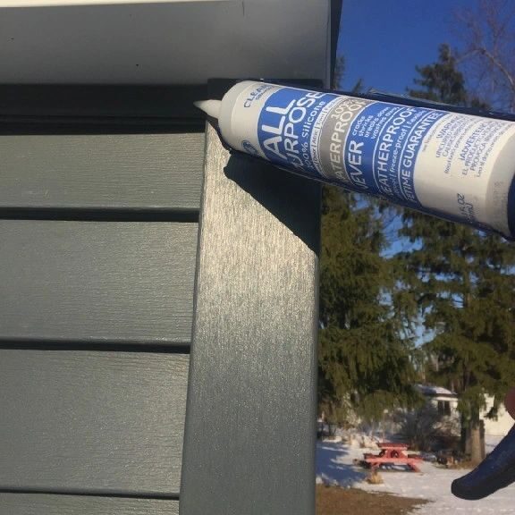 A close up of a tube of glue on the side of a house.