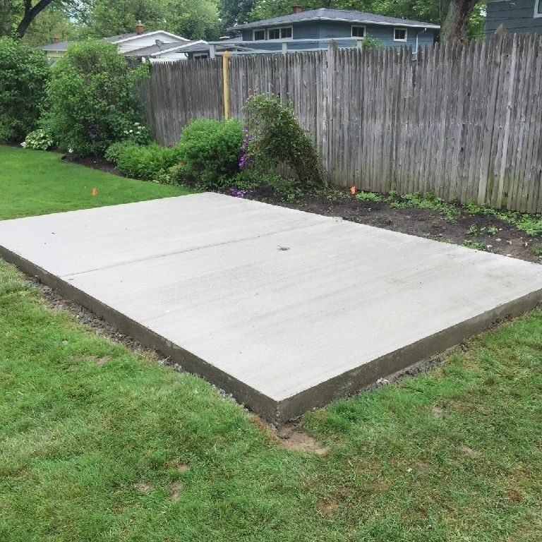 A concrete slab in the middle of a yard.